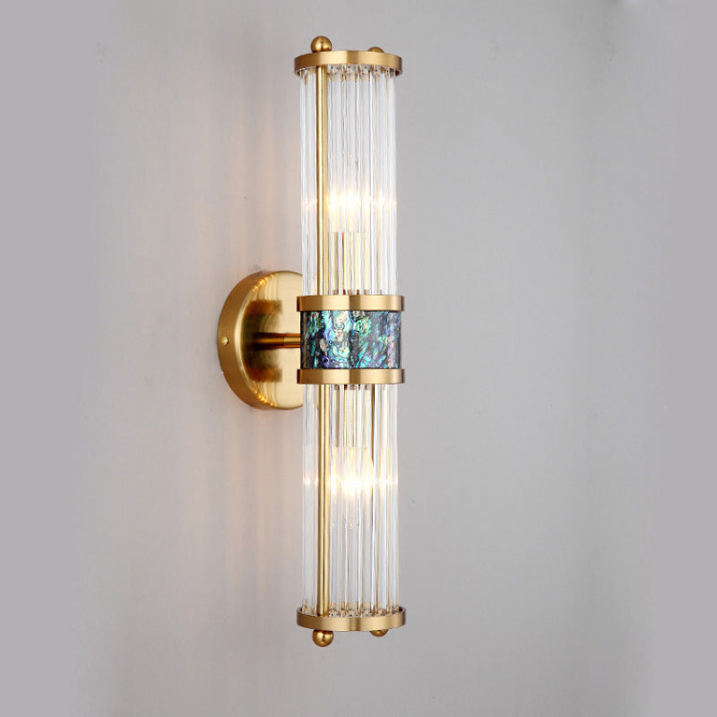 Oblique wall view of clear vertical rods, gold-tone round plate and blue-green central band
