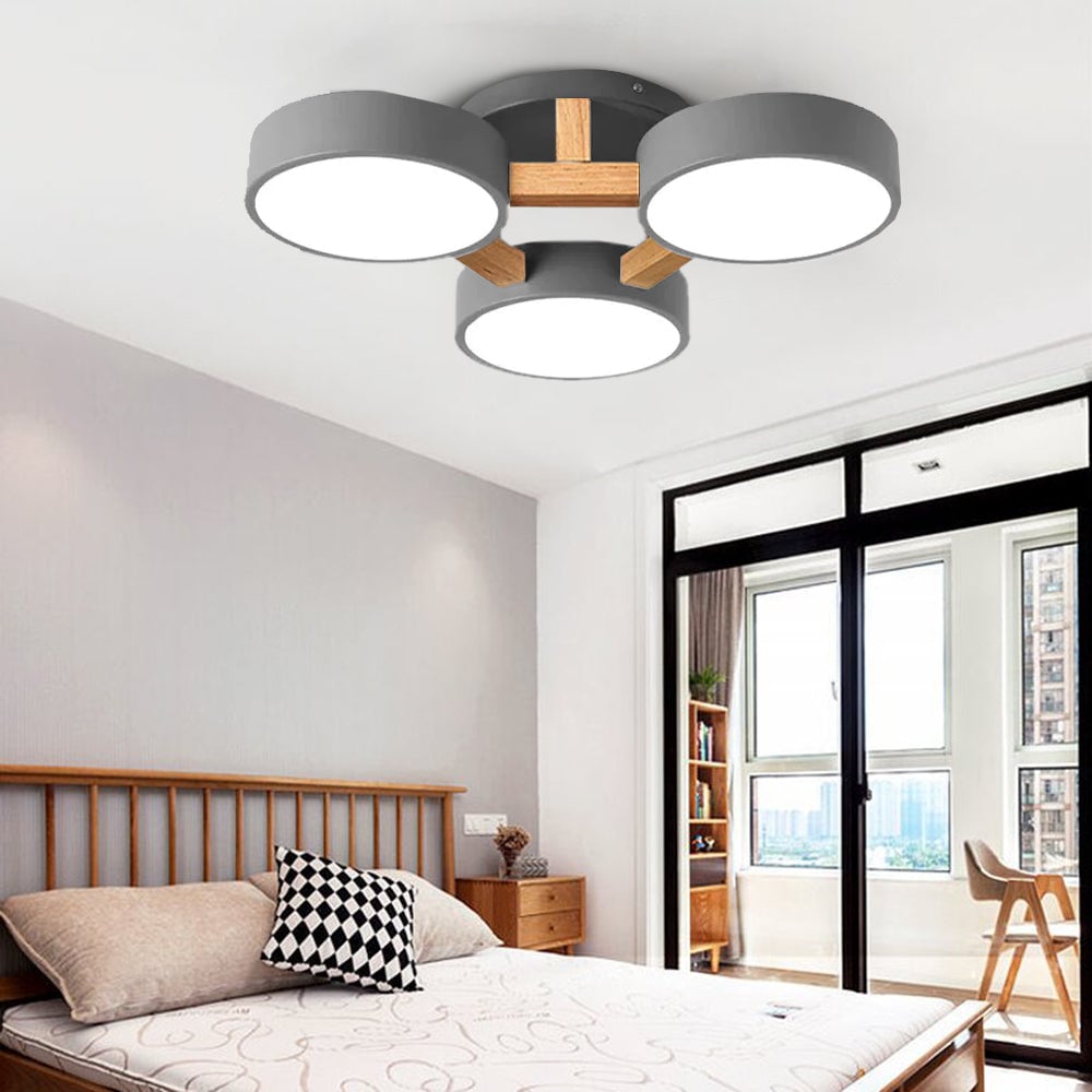 Gray Minori three-disc ceiling light above a bed beside a bright window.