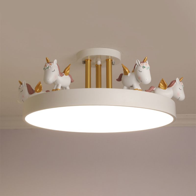 White unicorn ceiling light with gold-tone posts, raised figures and glowing round underside