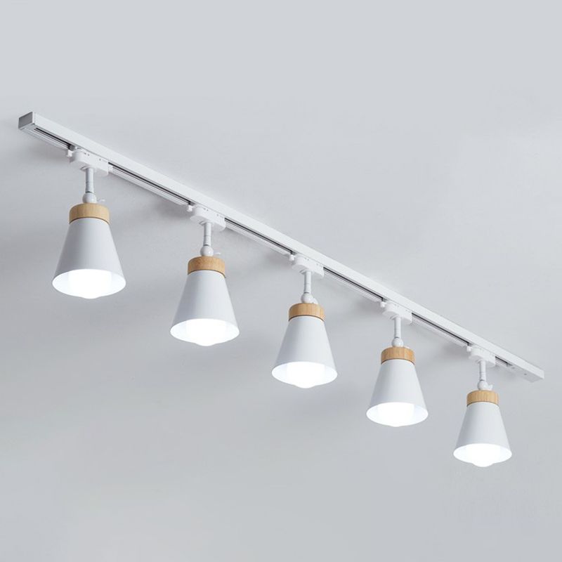 White Haney ceiling rail with five cone shades, light wood-tone collars, short stems and visible bulbs against gray background