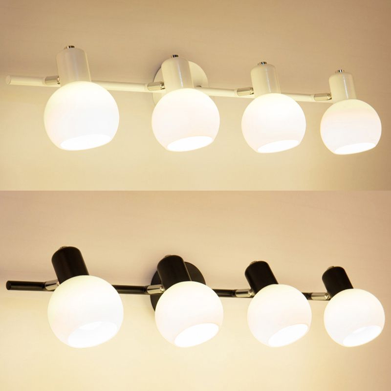 White and black Valentina four-head bars shown with round mounting plates and tilted globes