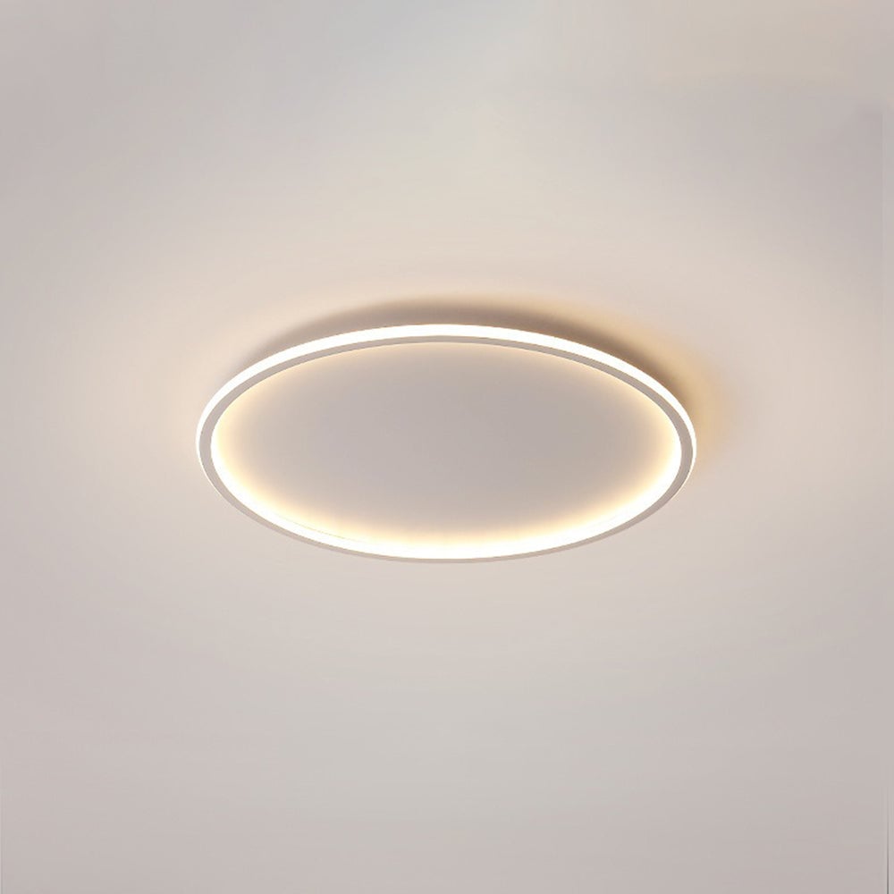 White-edged open-center ceiling ring with warm-looking light against a pale ceiling