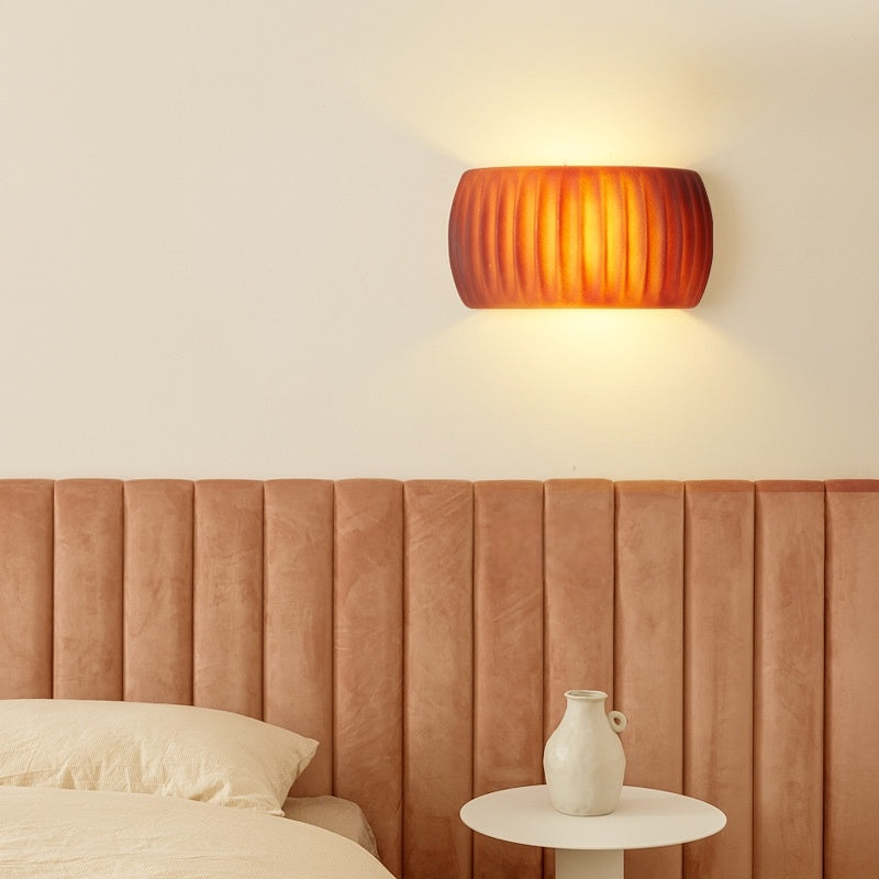Orange ribbed Hailie wall light above a bedroom headboard