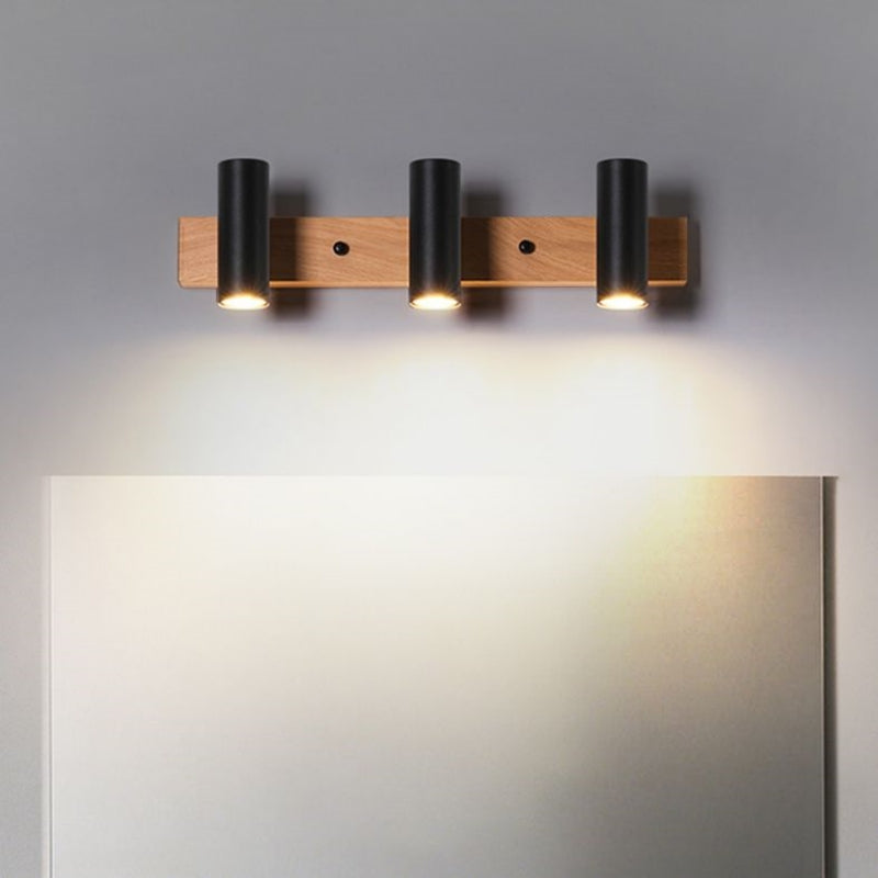 Three black Ozawa spot heads facing down on a wooden bar above a rectangular mirror