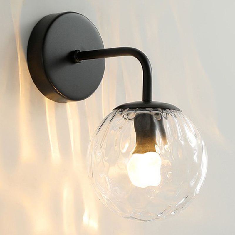 Side close-up of Black Valentina bent metal arm, round backplate and clear textured glass globe