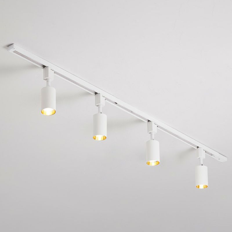 Small white four-head ceiling spotlight with short cylinders on a white rail