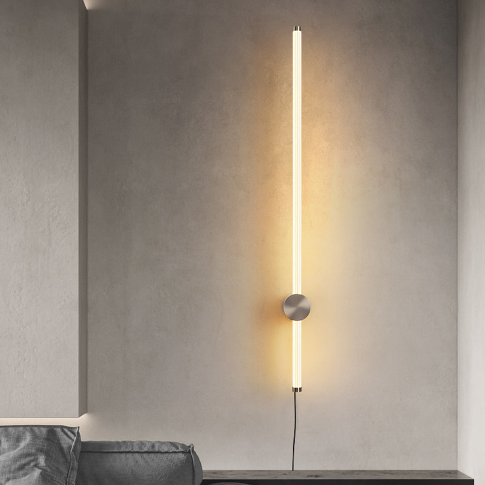 Front view of silver-tone Edge glowing rod wall light above a sideboard beside a sofa