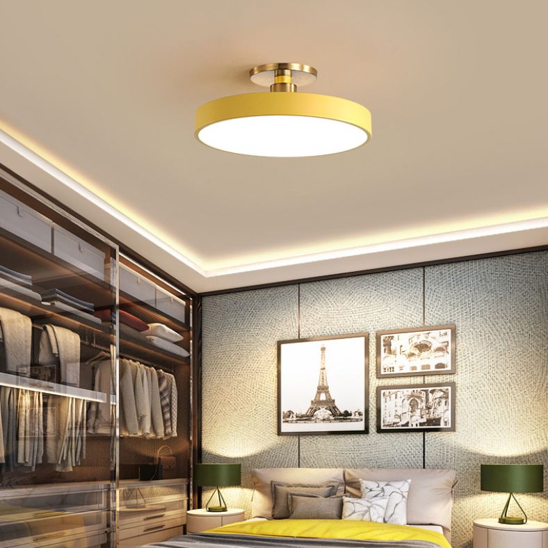 Yellow round ceiling fixture above a bedroom with a wardrobe and framed Paris pictures