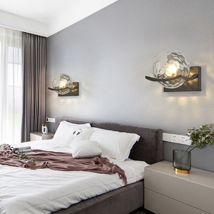 Two Valentina glass-globe wall lamps beside a bed
