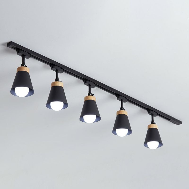 Black Haney ceiling rail with five cone shades, light wood-tone collars, short stems and visible bulbs against gray background