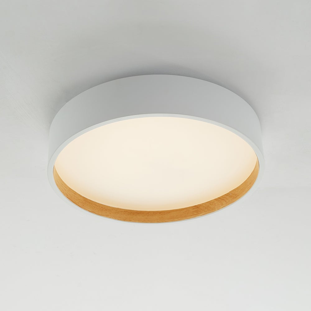 White Quinn ceiling drum from below, with warm-looking glowing circular panel and light wood-tone inner rim