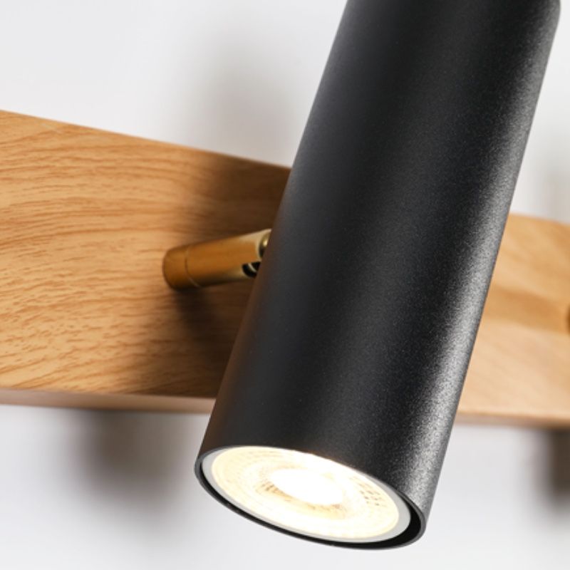 Close-up of black cylindrical spot opening, gold-tone pivot connector and wood-grain base