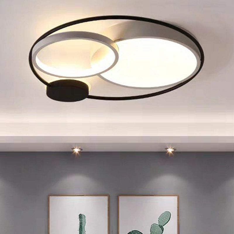 Black-and-white Lacey circular LED ceiling light illuminated above framed wall art.