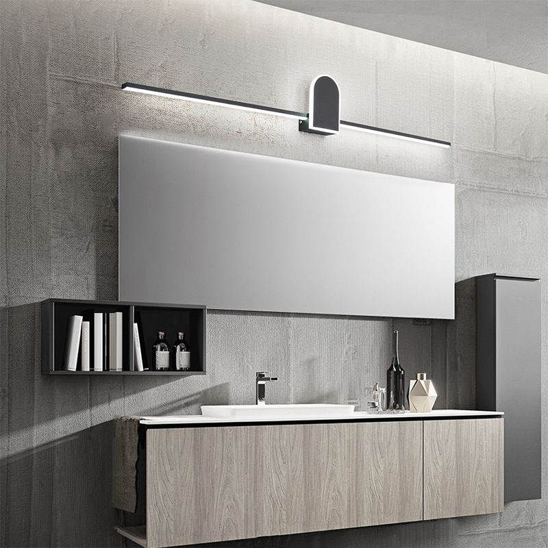 Black arch-detail wall lamp above a mirrored cabinet