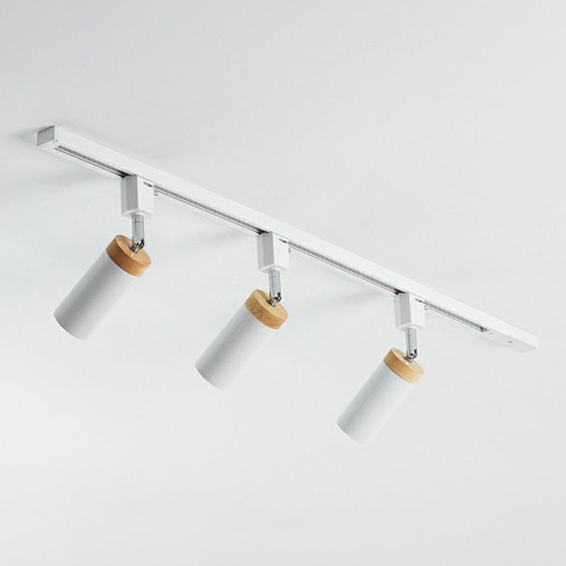 White three-head ceiling rail light with angled cylindrical spots and short silver-tone joints