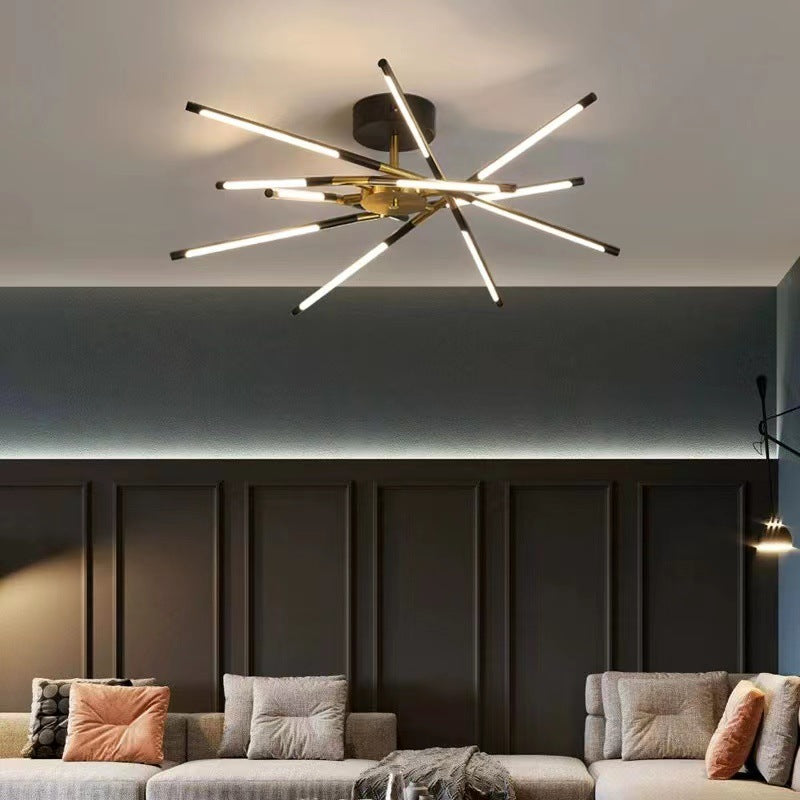Black and gold Edge ceiling light with luminous crossing bars above a sofa and dark wall panels
