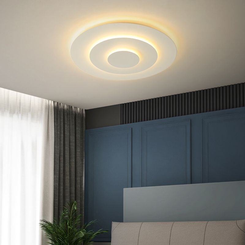 Quinn Style C concentric ceiling light glowing warmly above a bed
