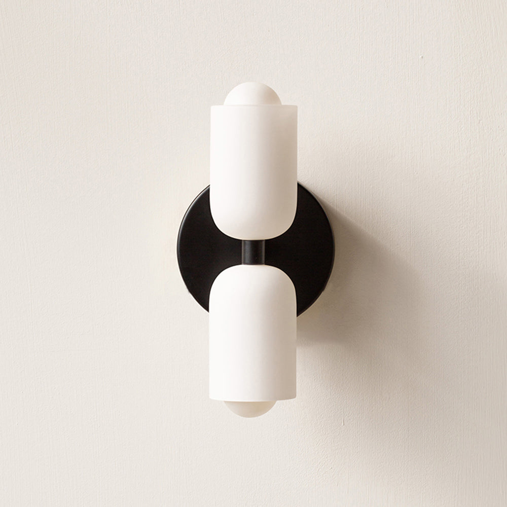 Black Morandi wall light with a circular backplate between two white cylinder shades.