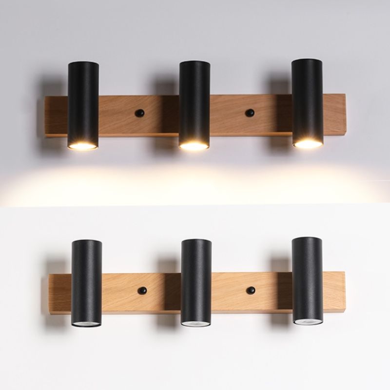 Two-photo comparison of three black Ozawa spots on a wooden bar, illuminated and unlit