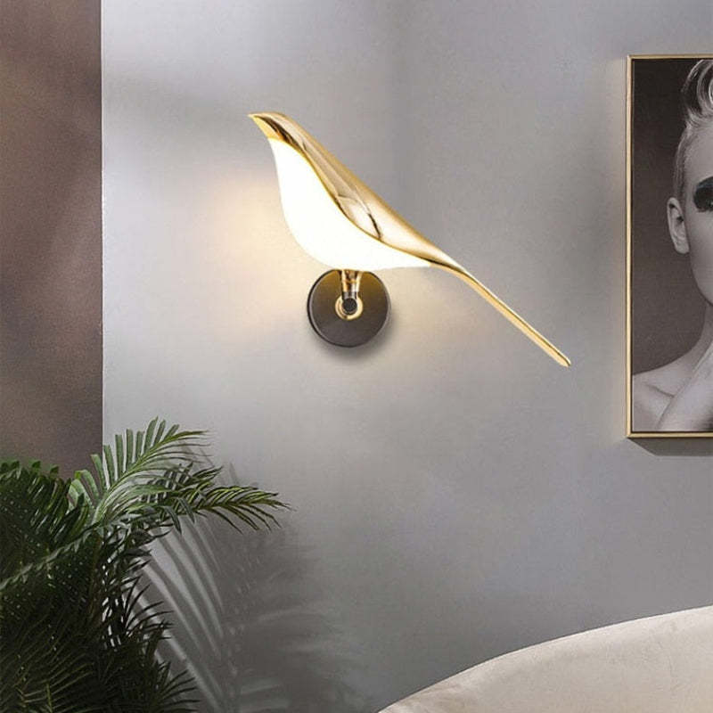 Single Gold bird wall light beside a plant