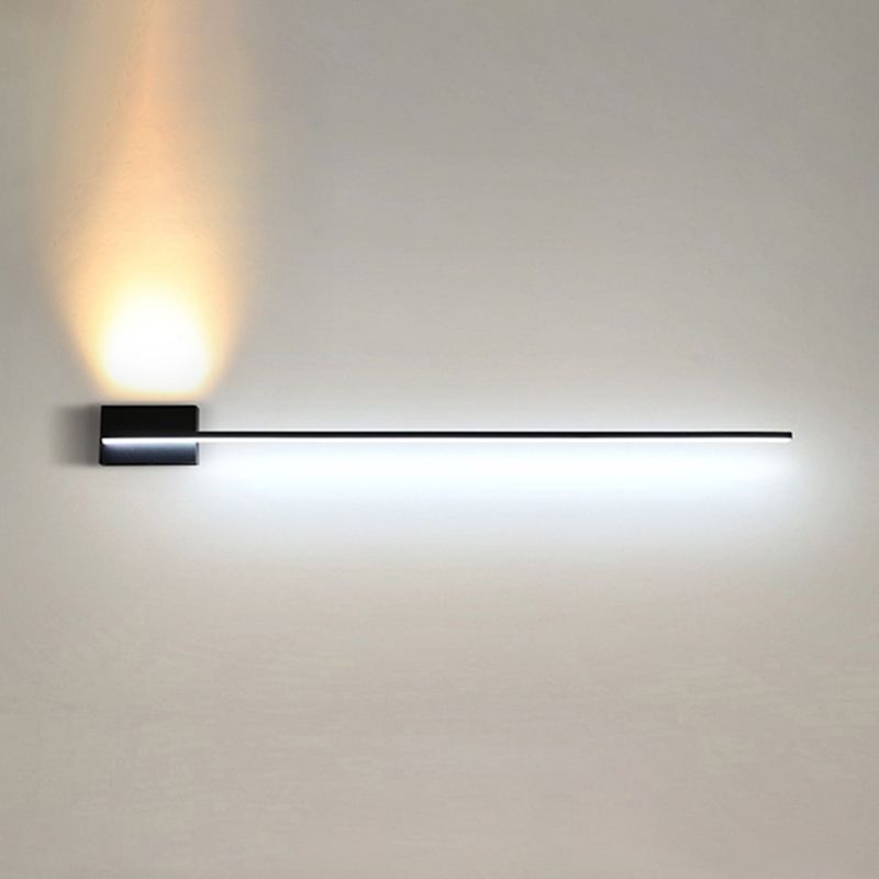 Installed black linear wall light with a white lower line and warm upward beam above its left plate