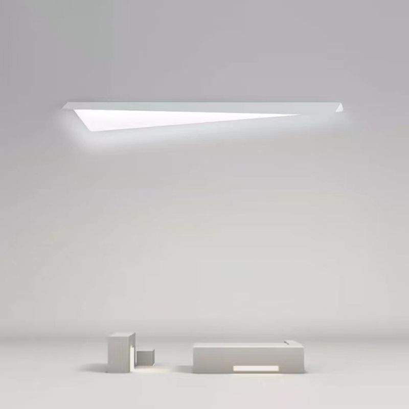 Leigh white asymmetric wall light above small block-shaped props on a pale background