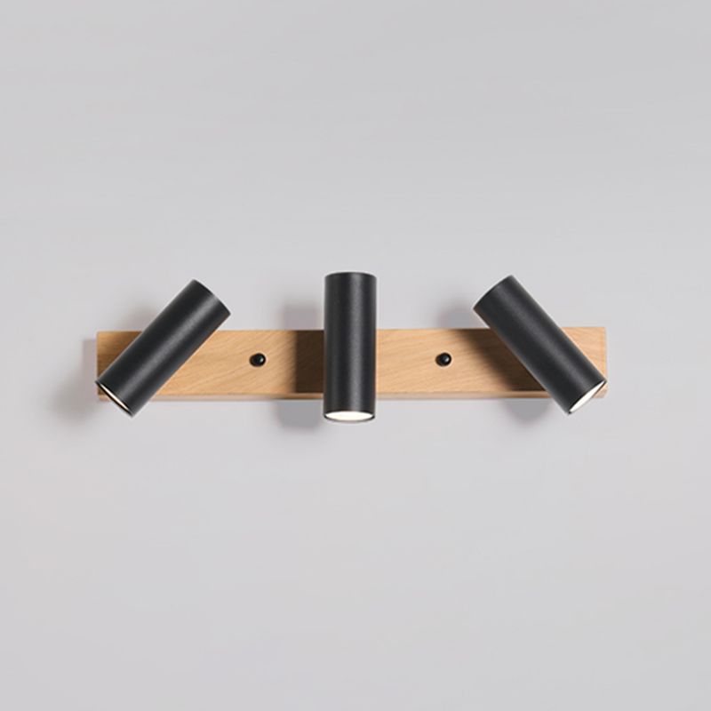 Three black cylindrical heads with the outer heads angled outward on a wood-grain-looking bar