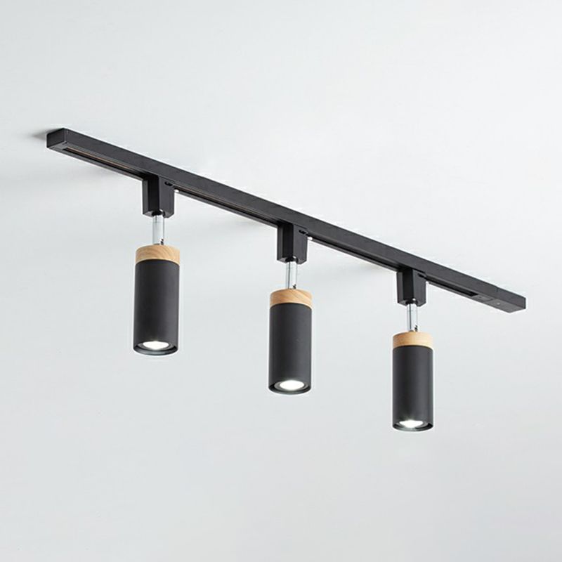 Black three-head ceiling rail fixture with downward tubular spotlights and contrasting tan collars