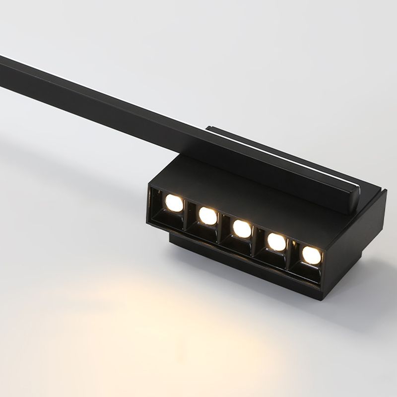 Close-up of five illuminated recessed emitters along the black wall-light plate