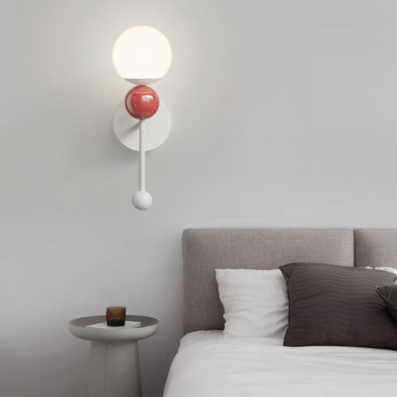 Red Hailie wall globe and lower decorative ball beside a bed
