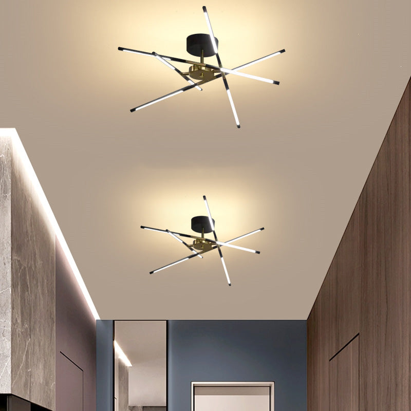 Two black and gold Edge ceiling fittings with crossed luminous bars along a corridor