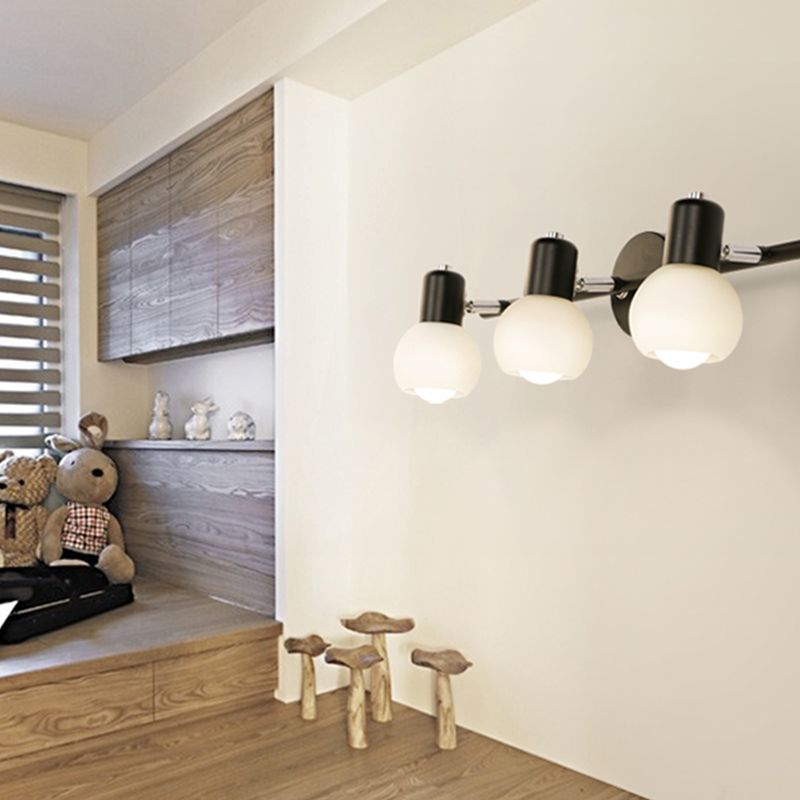 Black Valentina three-globe wall bar near wooden cabinetry and decorative toys