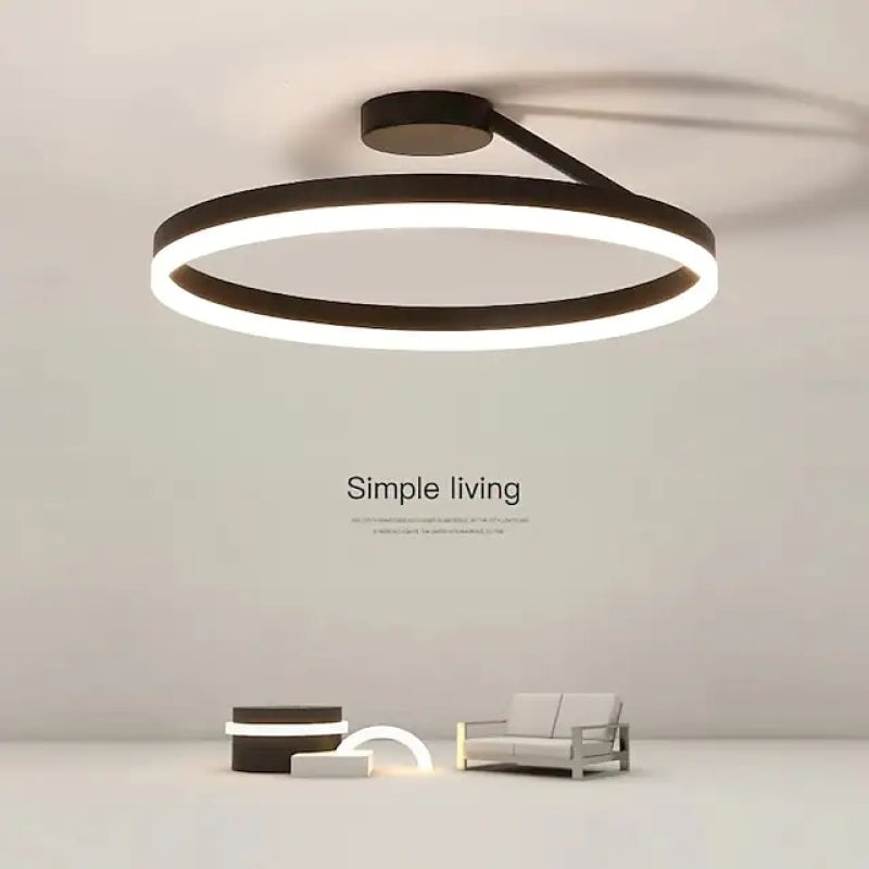 Black illuminated ring ceiling fixture above a room scene with a chair and Simple Living wall text