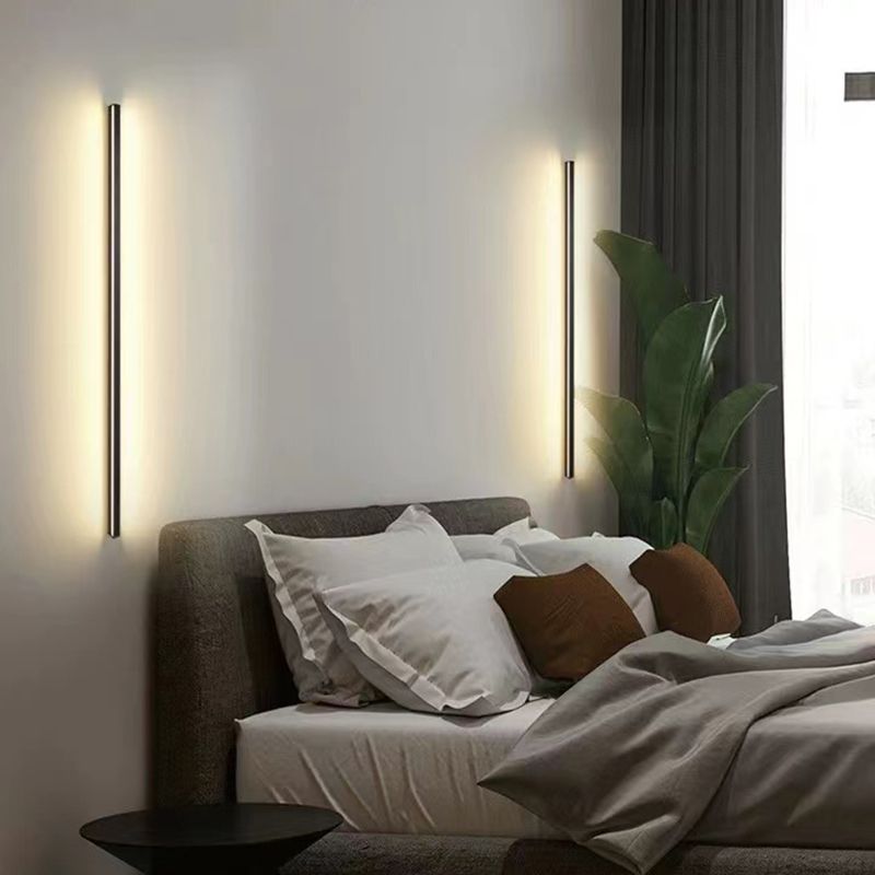 Two vertical glowing Edge black wall bars flanking a bedhead beside a plant and dark curtains