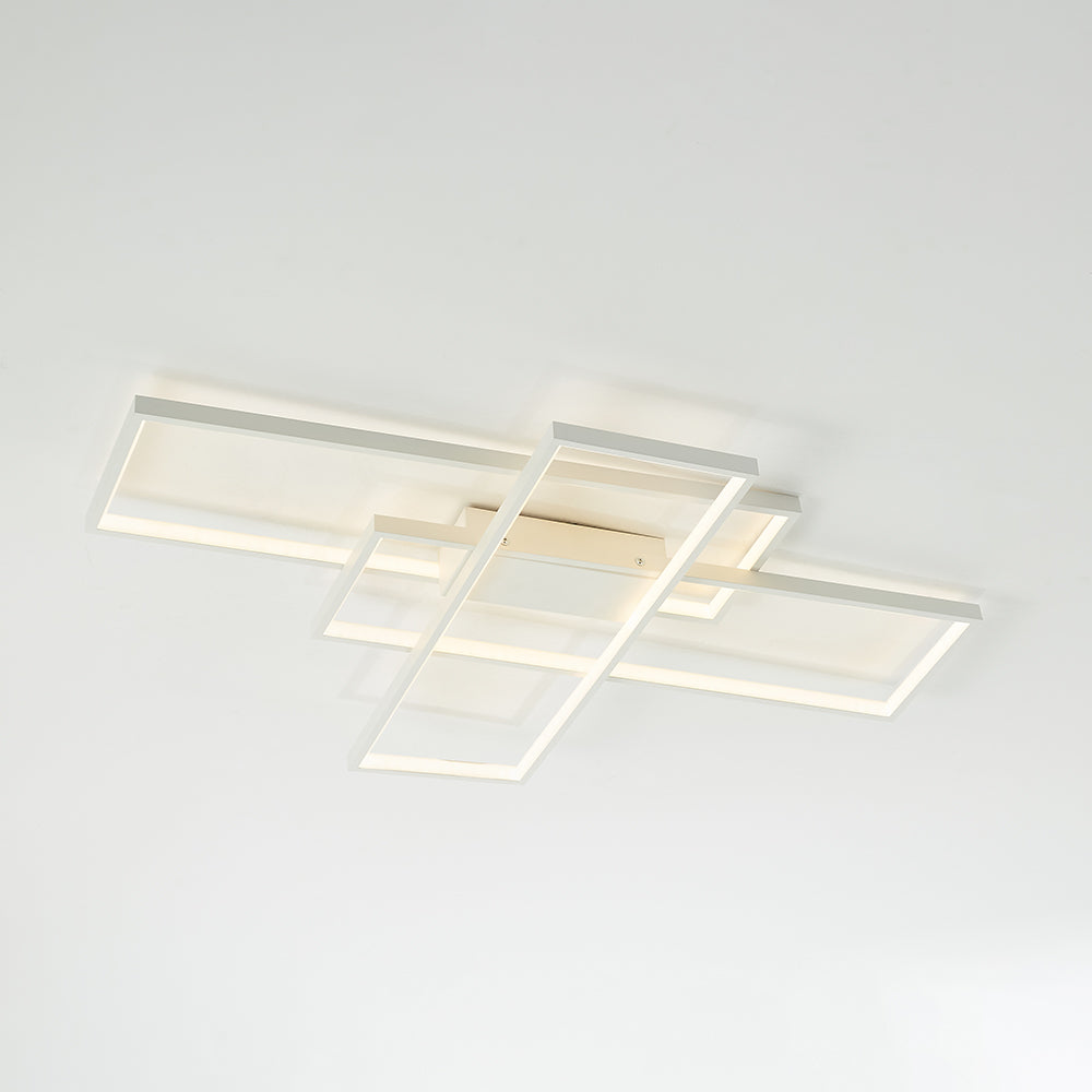 Oblique underside view of white overlapping rectangular frames, illuminated strips and central ceiling housing
