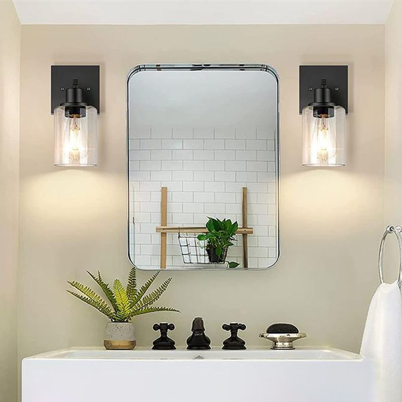 Two separate black Alessio single-light fittings beside a mirror above a washbasin