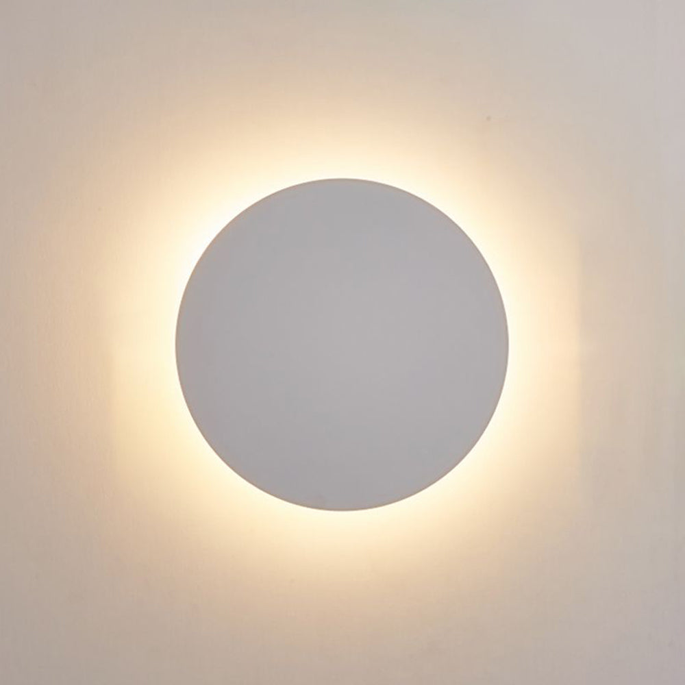 White round disc wall light close-up with a warm-looking perimeter halo