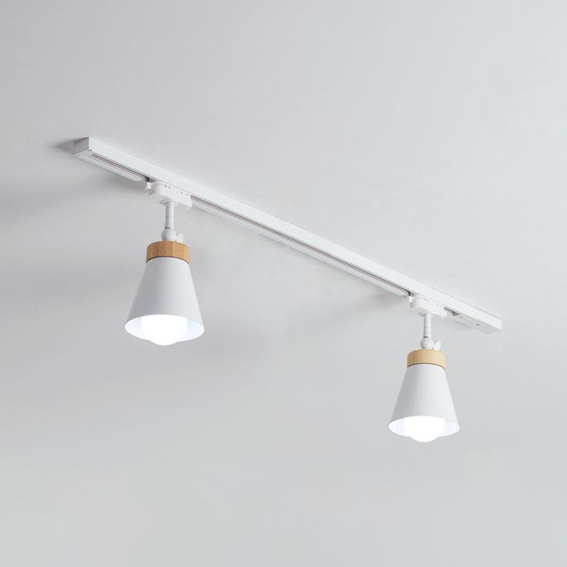 White Haney ceiling rail with two cone shades, short stems, light wood-tone collars and visible bulbs against pale background