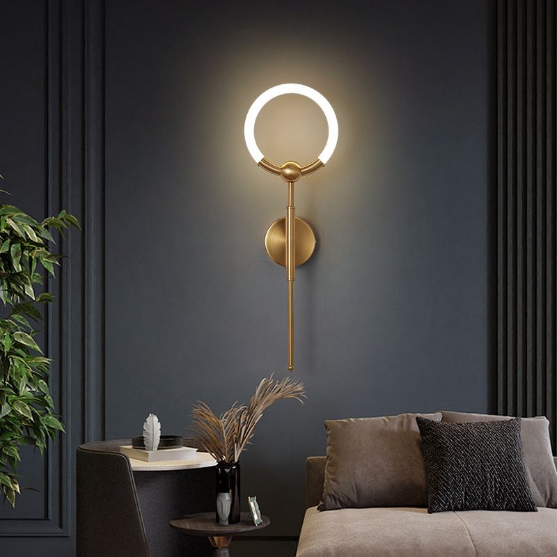 Gold Arisha ring wall light above seating on a dark wall