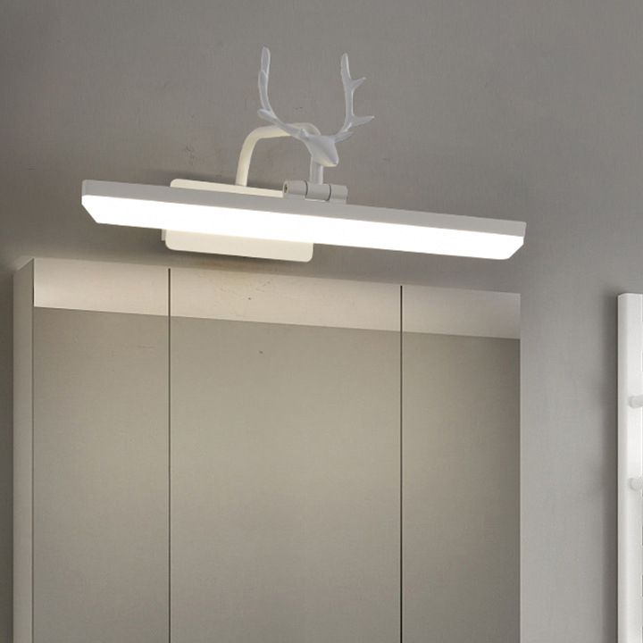 White antler wall light with a glowing straight diffuser bar above a mirrored cabinet against a gray wall