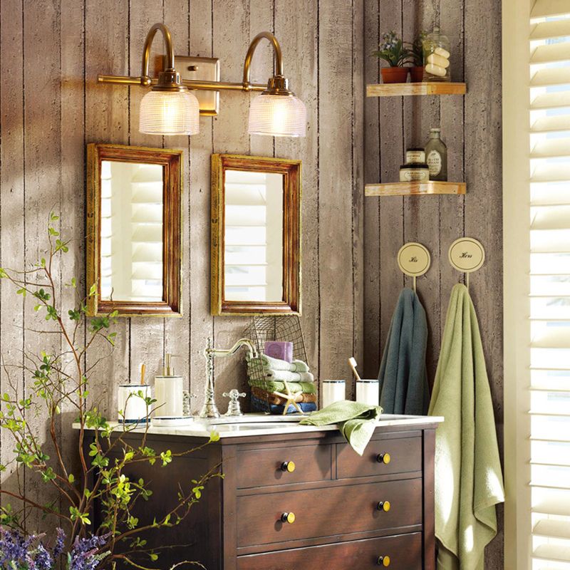Lottie two-light glass wall fixture above two small mirrors and a bathroom vanity with towels