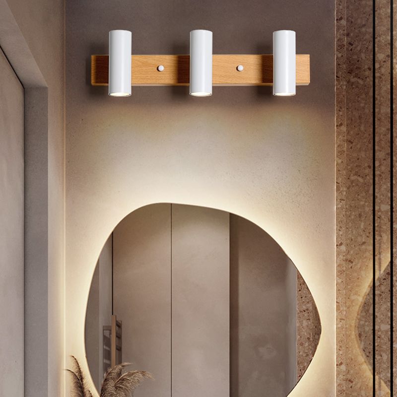 Three white vertical heads above an oval mirror on a brown textured wall