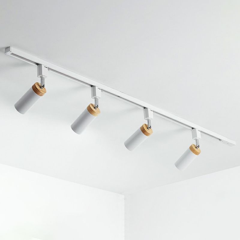 White four-head rail fixture with tilted tubular spotlights and tan woodgrain-look top collars