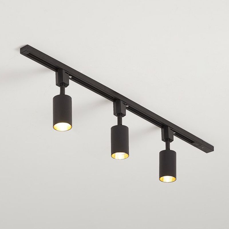 Small black three-head ceiling spotlight with short cylinders on a black rail