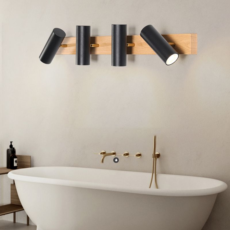 Four black cylinder heads above a white bathtub, with the outer heads angled and a gold-coloured tap below