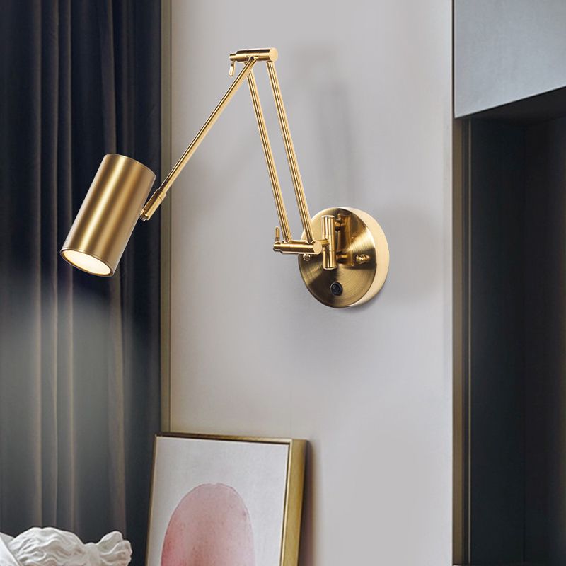 Freja Brass option with upright paired rods, diagonal arm and cylindrical shade beside a curtain and artwork
