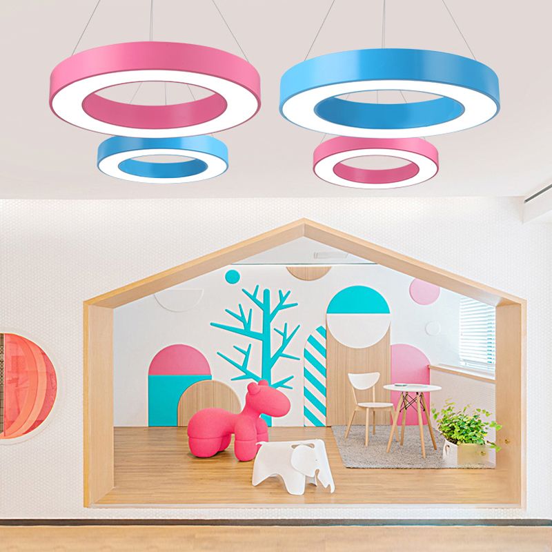 Pink and blue ring pendants over wooden-framed play area with animal-shaped toys, tables and plants