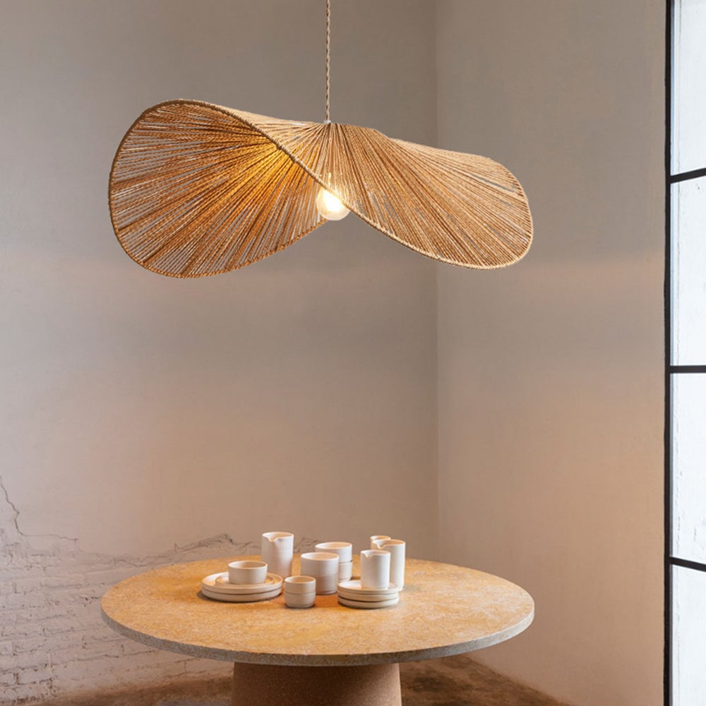 Brown Muto pendant above round stone-look table with cups and plates beside a window