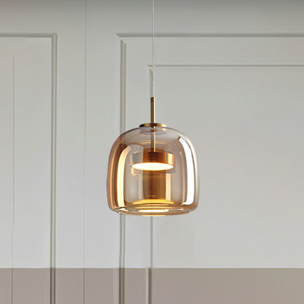 Compact taller amber Hailie glass shade with gold-tone inner stem and glowing disc against paneled wall
