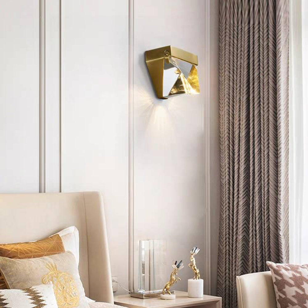 Gold Orr wall light beside a bed and curtain